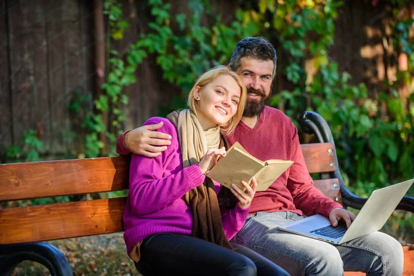 Couple with book and laptop search information. Share or exchange information knowledge. Information source concept. Man and woman use different information storage. Couple spend leisure reading.