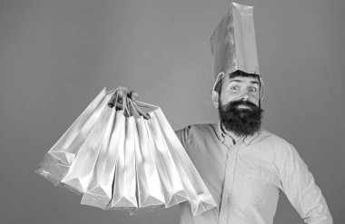 Gümüş çanta satış hakkında delirmek başındaki adam eğlenceli ve sevinç bir kavram. Pembe gömlekli alışveriş yaparken şık sakallı hippi. Sakallı adam ile mavi arka plan üzerinde mevcut paketleri isolalated