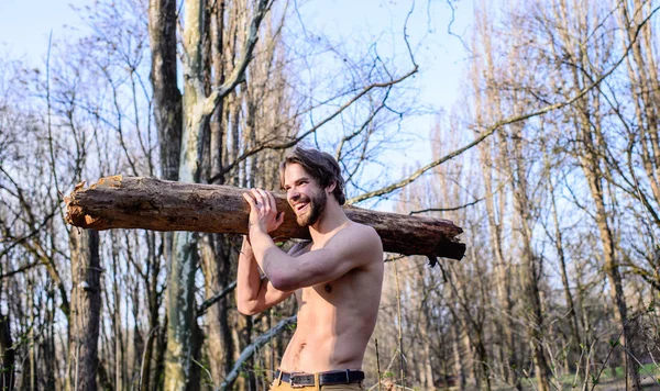 Drwal lub woodman sexy nagie mięśni tułowia zbieranie drewna. Pustelnik styl życia. Man brutalnie sexy drwal nosić duże dziennika na ramieniu. Brutalne silny facet atrakcyjny człowiek zbieranie drewna w lesie — Zdjęcie stockowe