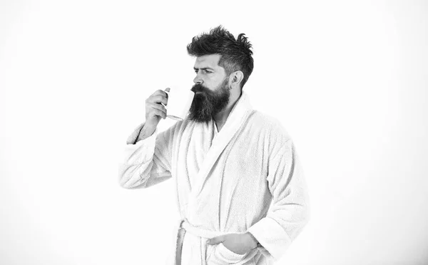 Un bel homme en peignoir tenant une tasse isolée sur fond blanc. Un barbu qui boit du café ou du thé le matin. Sérénité matinale — Photo