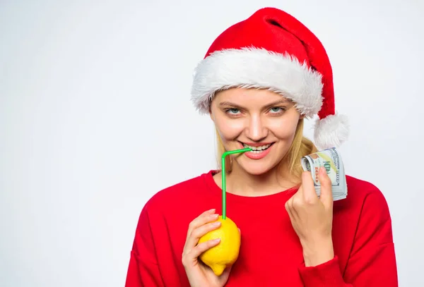 Koncepcja pieniądza cytryny. Dziewczyna santa hat pić sok cytryny słomy podczas przytrzymaj kupę pieniędzy. Symbol bogactwa i dobrobytu. Życzenia świąteczne. Rich girl z cytryną i pieniądze. Milioner kobieta cytryna — Zdjęcie stockowe