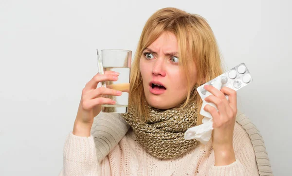 Ways to feel better fast. Flu home remedies. Get rid of flu. Woman wear warm scarf because illness or flu. Girl hold glass water tablets and thermometer light background close up. Getting fast relief