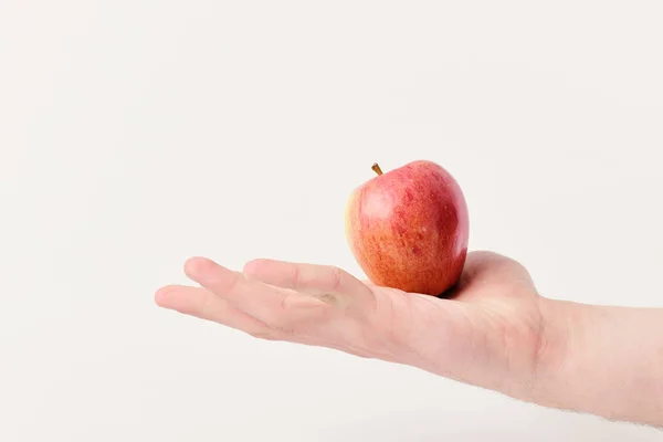 Männliche Hand hält hellroten Apfel. Apfel in saftiger Farbe — Stockfoto
