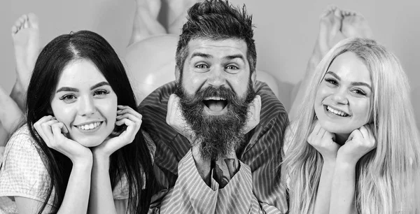 Conceito de manhã alegre. Homem e mulher, amigos em rostos sorridentes leigos, fundo rosa. Amantes apaixonados felizes juntos. Homens e mulheres barbudos em roupas domésticas, pijamas. Trio relaxante em mornin — Fotografia de Stock