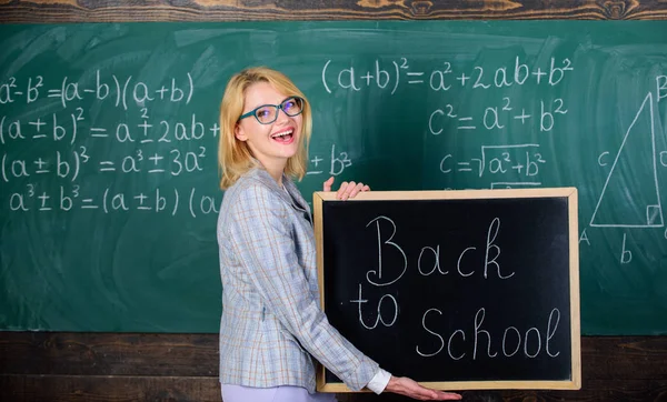 Meilleures façons d'accueillir les élèves à l'école. La maîtresse garde l'inscription au tableau noir à l'école. C'est encore l'heure de l'école. Professeur d'école heureux élèves bienvenus. Grand début d'école oui — Photo