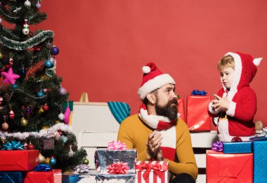 Noel Baba küçük şirin bir çocuğa hediye veriyor.