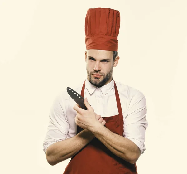 Cook with curious face holds knife. Kitchenware and cooking concept.