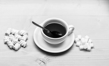 İçki ve tatlı hazırlanan tatlılar. Çay molası kavramı. Siyah çay ve tatlılar ile kupa. Siyah çay demlendi, kaşık ve yığın Beyaz ahşap zemin üzerinde rafine şeker ve lokum dolu kupa