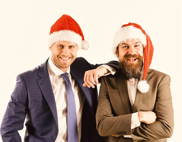 Men in smart suits and Santa hats on white background