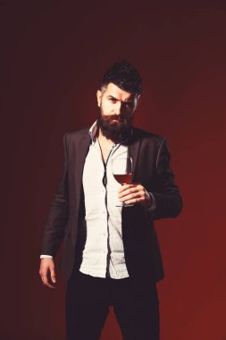 Burgonya kökenli sakallı bir şarap garsonu. Takım elbiseli adam kadeh kaldırıyor.