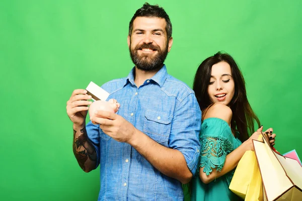 Couple in love holds shopping bags on green background — Stock Photo, Image