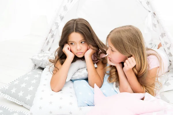 Pajamas party for kids. Cozy place tipi house. Sisters or best friends spend time together lay in tipi house. Girls having fun tipi house. Girlish leisure. Sisters share gossips having fun at home — Stock Photo, Image