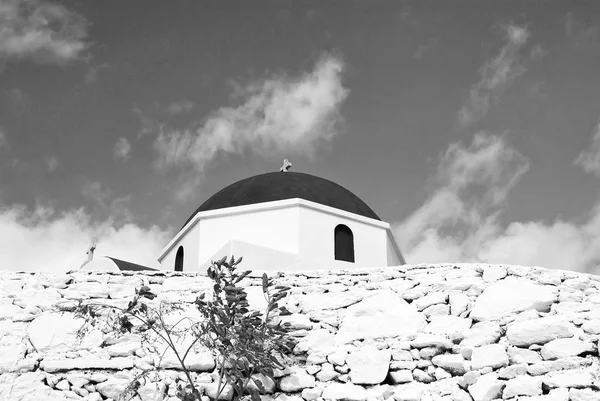 Recinzione in pietra e cupola rossa con dettaglio a croce a Mykonos, Grecia. Chiesa edificio architettura su soleggiato all'aperto. Cappella sul cielo blu. Religione e concetto di culto. Vacanze estive sull'isola mediterranea — Foto Stock