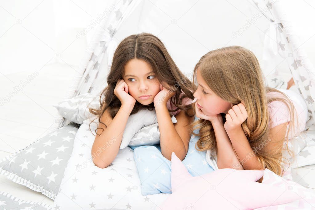 Pajamas party for kids. Cozy place tipi house. Sisters or best friends spend time together lay in tipi house. Girls having fun tipi house. Girlish leisure. Sisters share gossips having fun at home