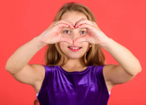 Symbol of love. Kid adorable girl with long hair smiling face show heart gesture to you. Celebrate valentines day. Love and sympathy. Love concept. Girl cute child show heart shaped hand gesture — Stock Photo, Image