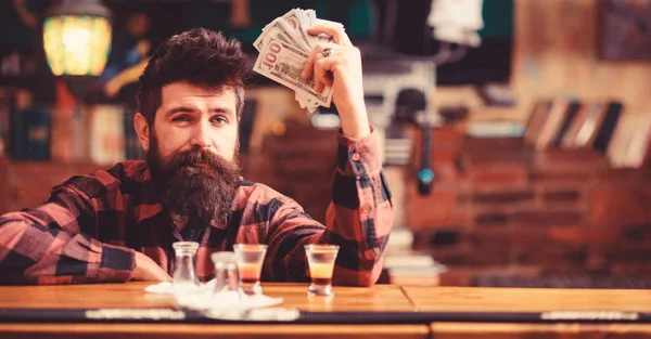 Hipster holds money, counting cash to buy more alcohol.