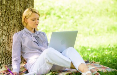 Açık havada faydaları iş. Eğitim teknolojisi ve internet kavramı. Dizüstü bilgisayar işleriyle açık havada ağaç gövdesinde yağsız olan kadın. Park içinde laptop ile kız iş çimenlerin üzerinde oturmak. Doğal ortamda office