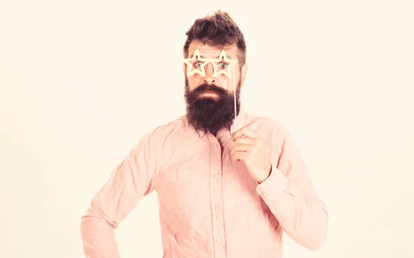 Homme tient accessoires de fête lunettes en forme d'étoile, fond blanc. Hipster avec barbe et moustache sur le visage joyeux surpris posant avec des lunettes en forme d'étoile, espace de copie. Concept de superstar — Photo