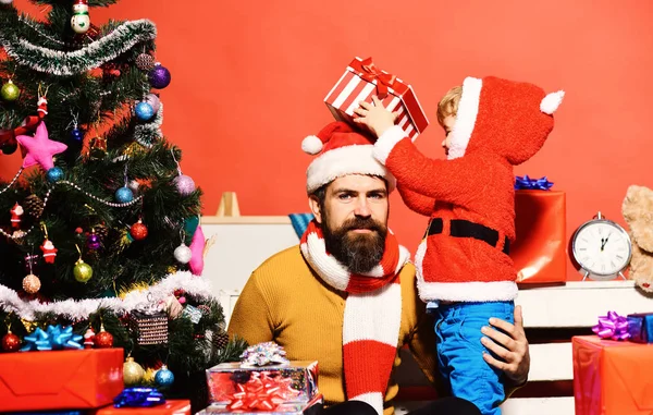 Familia de Navidad abre regalos sobre fondo rojo. — Foto de Stock