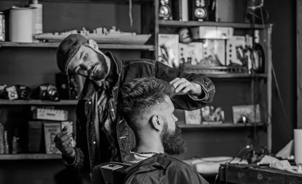 Client Hipster avec coupe de cheveux ou coiffure fraîche. Coiffure coiffeur de client barbu avec de la cire à la main. Concept de salon de coiffure. Homme avec barbe et moustache dans une chaise de coiffeur, étagères sur fond — Photo