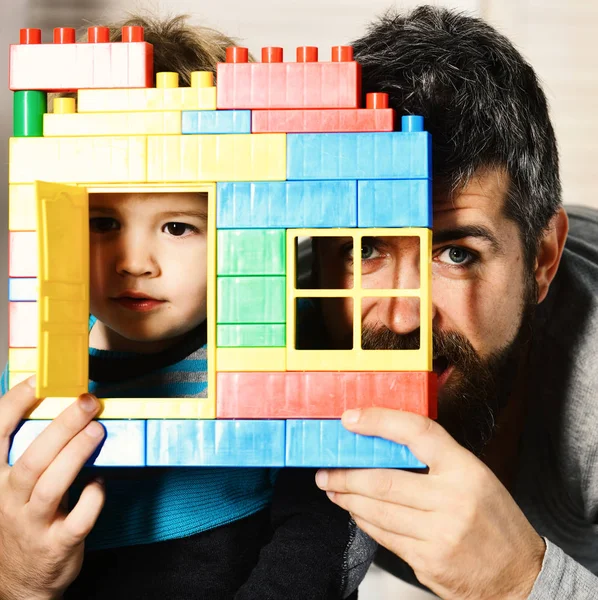 형형색색의 벽돌 건물 뒤에서 침착 한 얼굴을 하고 있는 아버지 와아들 — 스톡 사진