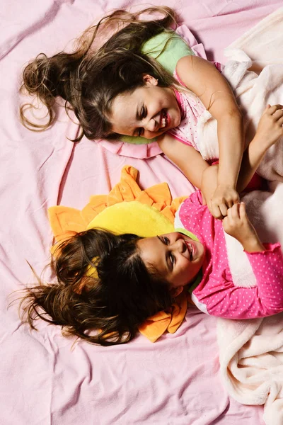 Los niños con caras felices se divierten acostados en la cama —  Fotos de Stock