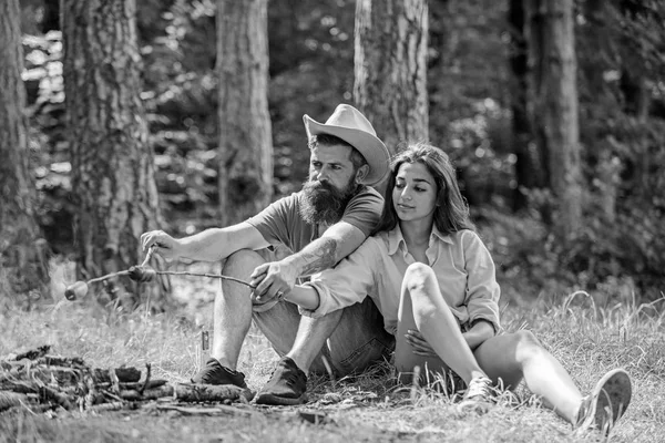 Casal no amor acampar floresta assar salsicha. Amigos de casal preparar salsichas assadas lanche natureza fundo. Caminhe piquenique comida assada tradicional. Hipster e menina assar comida. Actividade de campismo — Fotografia de Stock