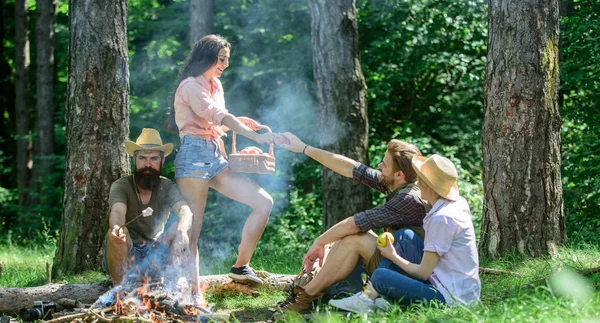Friends relaxing near bonfire. Friends enjoy picnic eat food nature forest background. Plan for perfect day hike picnic. Pleasant hike picnic in forest. Company friends or family relaxing picnic