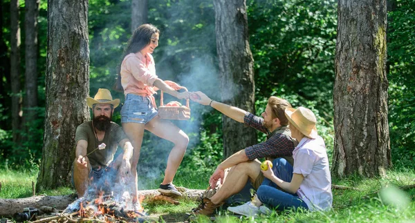 Amici rilassanti vicino al falò. Gli amici godono di pic-nic mangiare cibo natura foresta sfondo. Pianifica un perfetto picnic escursionistico. Piacevole escursione picnic nella foresta. Amici aziendali o in famiglia rilassante pic-nic — Foto Stock