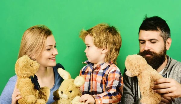 Man with beard, woman and boy play on green background.