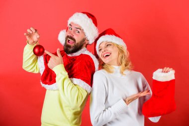 Kadın ve Santa sakallı adam bekliyor hediye kırmızı arka plan şapka. Onay içeriğini Noel çorap hediye aldı. Çift neşeli yüzü Hediyelik Noel çorap içinde kontrol. Noel hediye kavramı