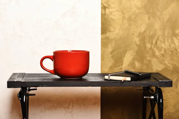 コーヒー ブレークは、生産的な一日概念。モダンなインテリアの黒いテーブルの上のホット コーヒー。ペンと屋内カップ日記。ブックマーク、ペン、スタイリッシュな壁の近くのテーブルの上の熱い飲み物のカップのノート — ストック写真