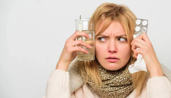 Ways to feel better fast. Flu home remedies. Woman wear warm scarf because illness or flu. Girl hold glass water tablets and thermometer light background close up. Get rid of flu. Getting fast relief