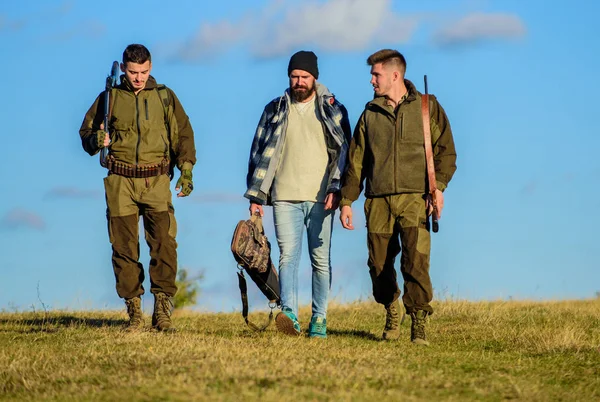 Groep mannen jagers of gamekeepers aard achtergrond blauwe hemel. Jongens verzameld voor de jacht. Mannen dragen jachtgeweren. Jacht als hobby en vrije tijd. Jagers met geweren lopen zonnige herfstdag. Brutale hobby — Stockfoto