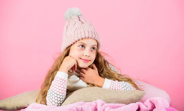 O miúdo sonhador usa um chapéu de malha. Descanse e relaxe. Conceito de temporada de inverno. Acessório de moda de inverno. Miúda de malha chapéu e cachecol. Conceito de acessório de inverno. Menina cabelo longo sonho rosa fundo — Fotografia de Stock