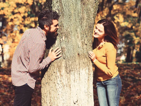 Ερωτευμένο ζευγάρι παίζει πίσω από το δέντρο στο πάρκο φθινόπωρο. — Φωτογραφία Αρχείου