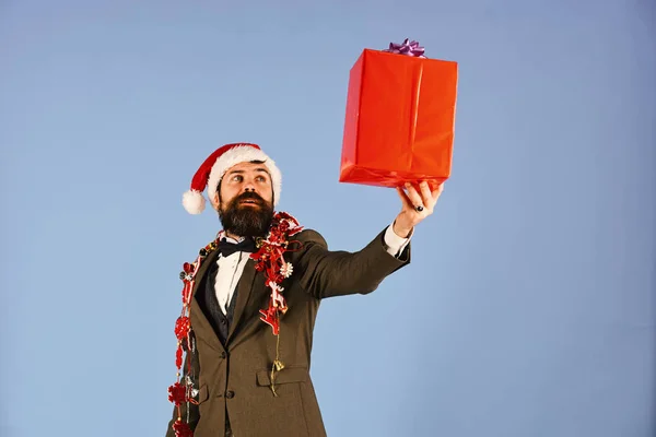 Mannen i smart kostym, Santa hatt och girlanger på blå — Stockfoto