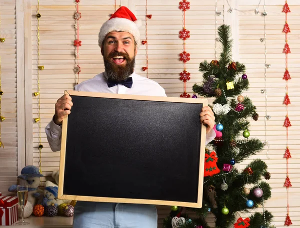 Homem com barba segura quadro-negro em branco, espaço de cópia . — Fotografia de Stock