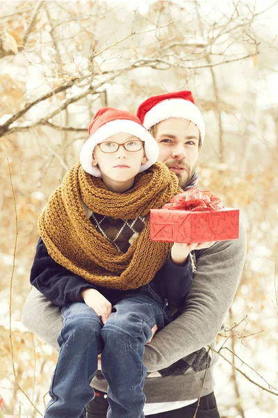 Рождественский мальчик и мужчина отец с подарком в зимний открытый — стоковое фото