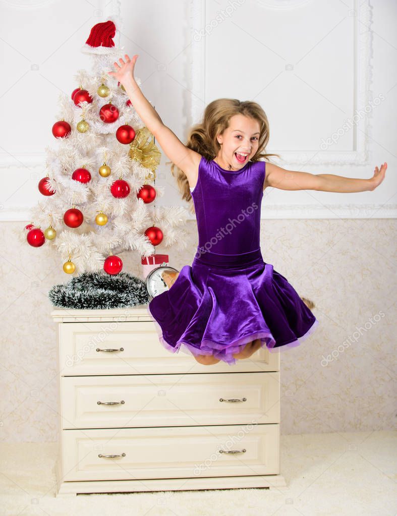 Child emotional cant stop her feelings. Girl in dress jumping. It is christmas. Day we have waited for all year finally here. Girl excited about christmas jump mid air. Celebrate christmas concept