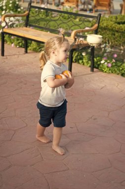 Şirin bebek çocuk yalınayak yürümek iki portakal ile