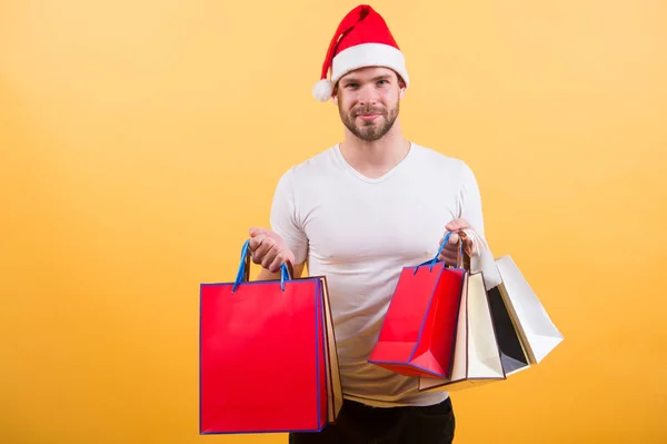 Mannen i santa hatt hålla julklapp. Online julhandeln. Gott Nytt År. leverans julklappar. lycklig santa man på gul bakgrund. På morgonen innan Xmas. God Jul — Stockfoto