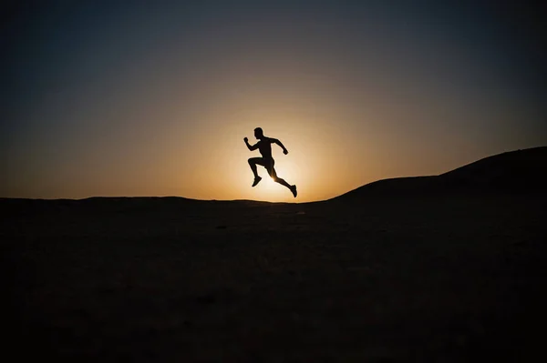 Correndo silhueta homem no céu por do sol — Fotografia de Stock