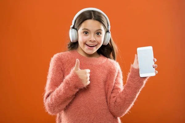 Dziecko dziewczynka słuchać muzyki nowoczesne słuchawki i smartphone. Pobierz muzyka subskrypcja dla rodzin z dziećmi. Dostęp do milionów utworów. Ciesz się koncepcja muzyki. Najlepsze aplikacje muzyczne, które zasługują na słuchać. Słuchaj za darmo — Zdjęcie stockowe