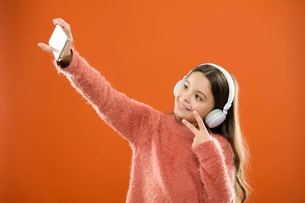 Získejte předplatné hudby. Užijte si hudební koncept. Nejlepší hudební aplikace, které si zaslouží, poslouchej. Poslouchejte zdarma. Mobilní aplikace pro mládež. Dívka dítě poslouchat hudbu moderní sluchátka a smartphone s selfie — Stock fotografie