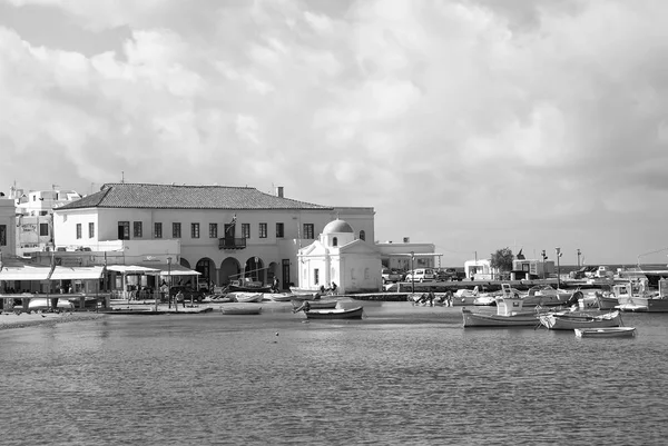 Mykonos, Görögország - május 04, 2010: Halászhajók a tengerparttól. A falu a tengerparton, a felhős ég. Egyház és a házak, a tenger partján. Nyaralás szigeten. Mehetnék és utazási koncepció — Stock Fotó