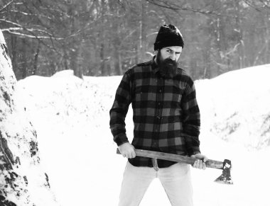 Yakışıklı adam veya oduncu, sakal ve bıyık kırmızı kareli gömlek standları kış günü açık havada doğal adam karlı ormanda balta ile sakallı hippi