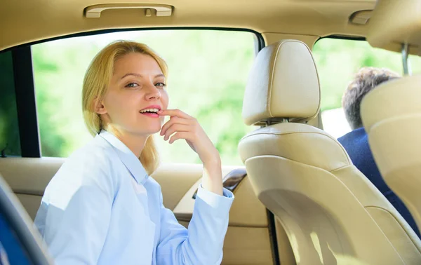 Business life concept. Business woman sit on backseat. Busy lady passenger leather car salon enjoy journey with chauffeur. Business lady passenger luxury car salon. Personal assistant and driver