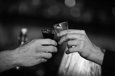 Erkek alkış bulanık bar arka plan üzerinde alkol ile eller.