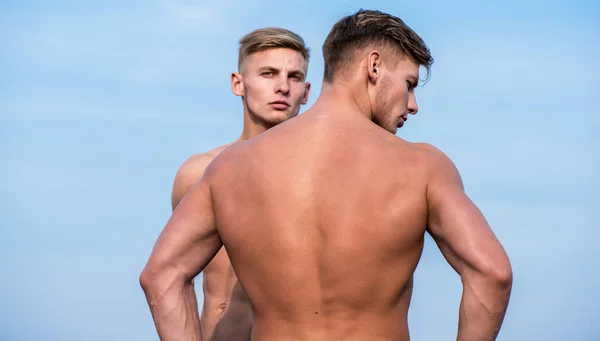 Support and connect concept. Attractive twins. Men muscular athlete bodybuilder show muscles. Strong muscles emphasize masculinity sexuality. Men muscular back naked torso stand sky background